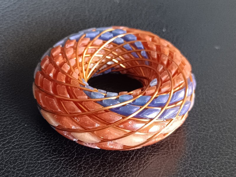 torus rodin coil pendant Sunrise Orange with flashes of pink and purple swirls gallery